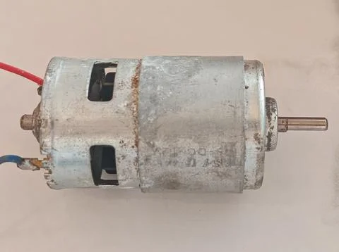 Small DC Electric Motor Component with Wires on Clean Background Foto stock