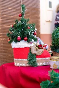 Small decorated Christmas tree on red market table 库存照片