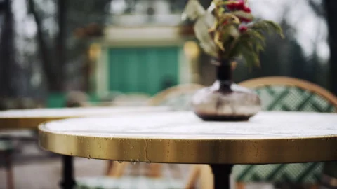Small decorative glass vase with winter berries and greenery on outdoor table Stock Footage 331056799