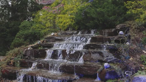 A small decorative waterfall in the Park or in the garden. Landscape design.Slow 스톡 동영상 154057392