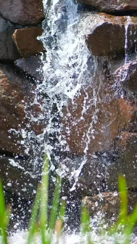 A small decorative waterfall in a park or garden. Landscape design. Slow moti Stock Footage 306148249