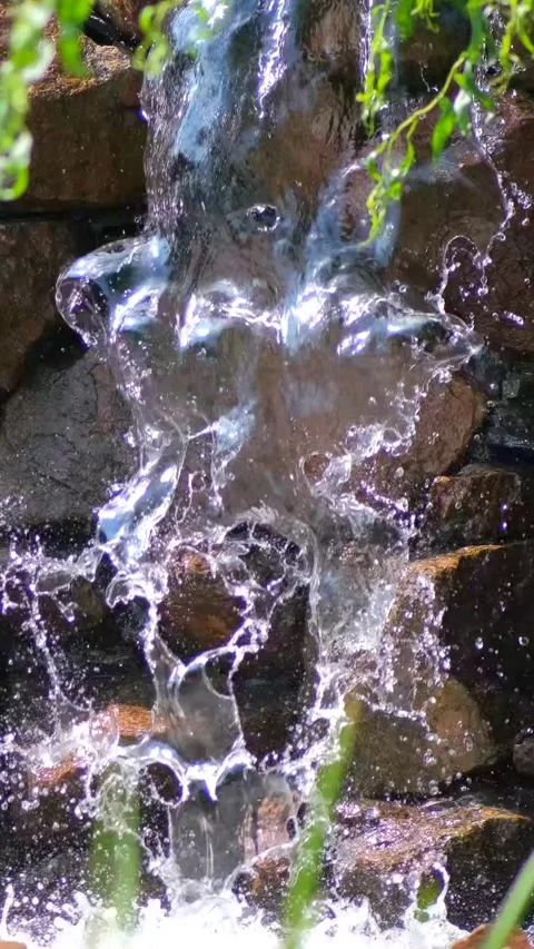 A small decorative waterfall in a park or garden. Landscape design. Slow moti Stock Footage 306148345