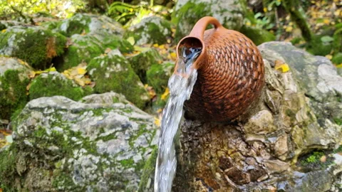 Small decorative waterfall from a pitcher in the public park. Video stock 223729027