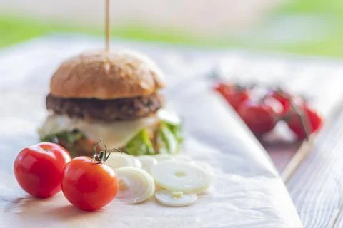 Small depth of field. Soft focus. Burger made it at home. Next to it are red  Stock Photos