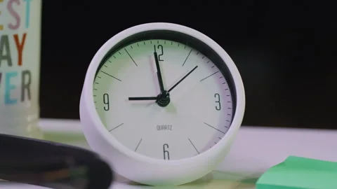 A small desk clock ticking in real time Stock Footage 345257785