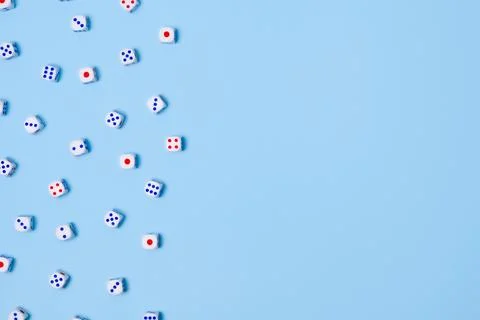 Small dice isolated on a blue background. Gambling devices. Copy space for text Stock Photos