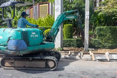 A small digger is working on the street Stock Photos