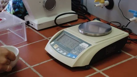 Small digital weights scales. Weigh the flask with a food product. Laboratory Stock Footage 74207413