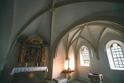 A small, dim chapel with a vaulted ceiling, a stained-glass window, an ornate Foto stock