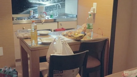 A small dinning table of the hotel room with food including water bottles, Stock Footage 121357687