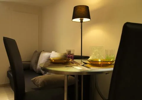 Small dinning table set closeup on low romantic light Stock-Fotos