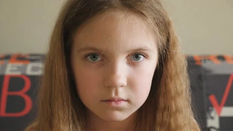 Small disappointed kid sitting on the couch and looking into camera. Portrait Video stock 140604824