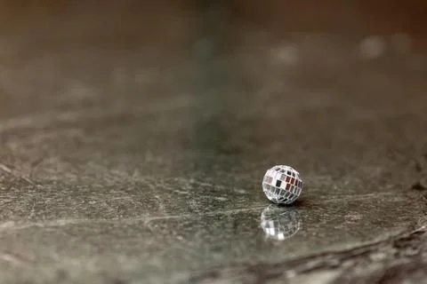 A small disco ball on a stone table. Club concept. New Year decoration Stock Photos