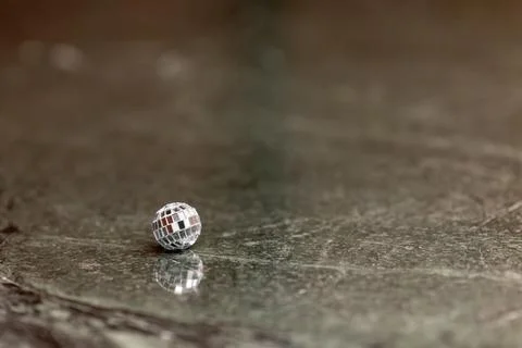 A small disco ball on a stone table. Club concept. New Year decoration Stock-Fotos