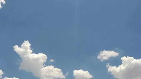 Small distant airplane flying through a clear bright blue sky Stock-Fotos