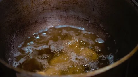 Small donuts are thrown into boiling oil. Cooking at home. cast iron boiler Stock Footage 224836983