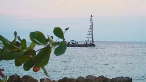 Small drill platform drifts into the sea. People work on a platform in the se Stock Footage 93368452