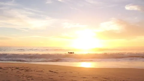 Small drone flying low over the beach at sunset 스톡 동영상 154409712