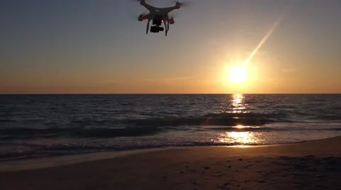 Small drone flying by a sunset at the beach Video stock 56948172