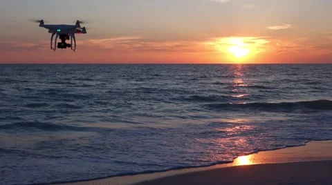 Small drone flying at sunset on the beach Video stock 56948579