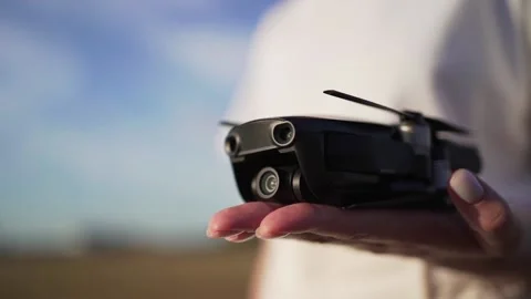 A small drone in hands. Electronic gadget for work and hobby. Quadcopter Stock Footage 136659233
