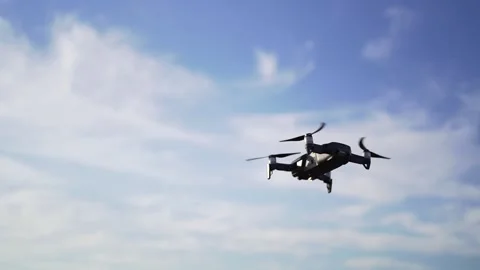 A small drone hovered in the sky at sunset, against the clouds. Professional Vidéo 136237430
