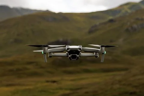 Small drone hovering over remote green highlands Stock Photos