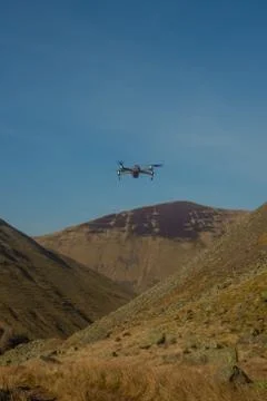 A Small Drone Hovers Above a Remote Valley in Scotland Stock Photos