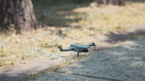 Small drone landing on the ground, slow motion Stock Footage 276096626