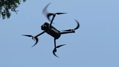 Small drone quadcopter hovering in air Stock Footage 325212969