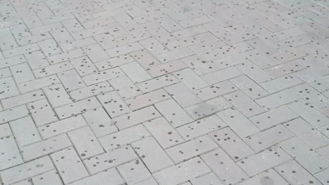 Small drops of rain begin to fall on the paving stones of the pedestrian Stock Footage 344667662
