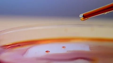 Small drops of red blood falling from a glassy tube on a round sauce with blood Stock-Footage 127317970