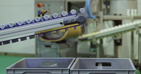 Small drug bottles move through automated production line and fall down into box Stock Footage 346230768