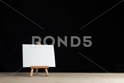 A small easel, a layout, a blank, white on a black background. Stock Photos