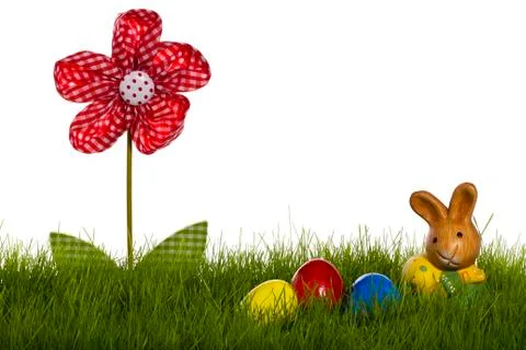 Small easter bunny with easter eggs and drapery flower in grass Stock Photos