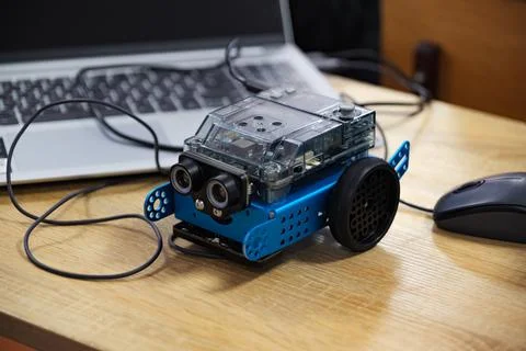Small educational robot connected to laptop on desk. 스톡 사진
