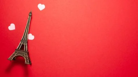 The small Eiffel Tower, pink small hearts on red background. Paris sight Stockfoto's