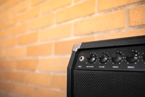 Small electric guitar amplifier with brick wall Stock Photos