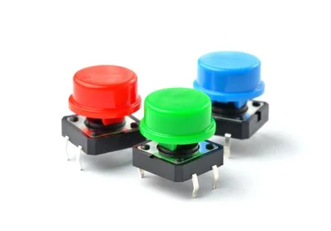 Small electronic tactile toggle push buttons switch with multicolored hats Foto stock