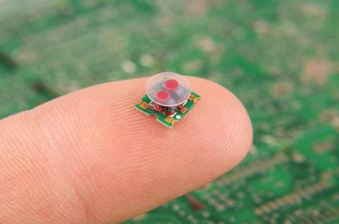 Small electronics component RF transformer on human finger Stock Photos