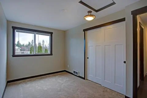 Small empty bedroom with white doors closet. Stock Photos