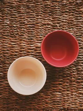 Small empty ceramic measure bowls on rustic wicker background, food preparati Stock Photos