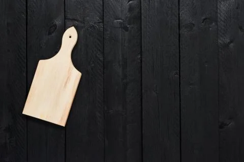 Small empty chopping board on black wooden table Stock Photos