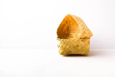 Small empty hand-woven bamboo wicker container placed side way inside lid. Stock Photos
