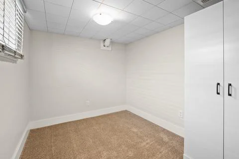 Small, empty room with a white closet and a light hanging from the ceiling Stock Photos