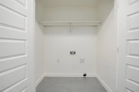 Small, empty room with a white door and a white wall Stock Photos