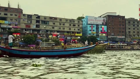 Small Engine boat and loaded cargo ship crossing buriganga river at sadarghat - Stock Footage 334811465