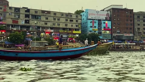 Small Engine boat with loaded cargo ship crossing buriganga river at sadarghat Stock Footage 334797466