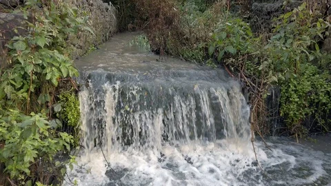 Small English waterfall stream cascading along brickwork waterway channel. Stock Footage 118288601