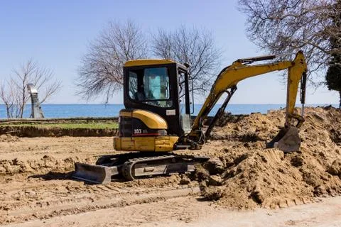 Small excavator digging sand Stock Photos